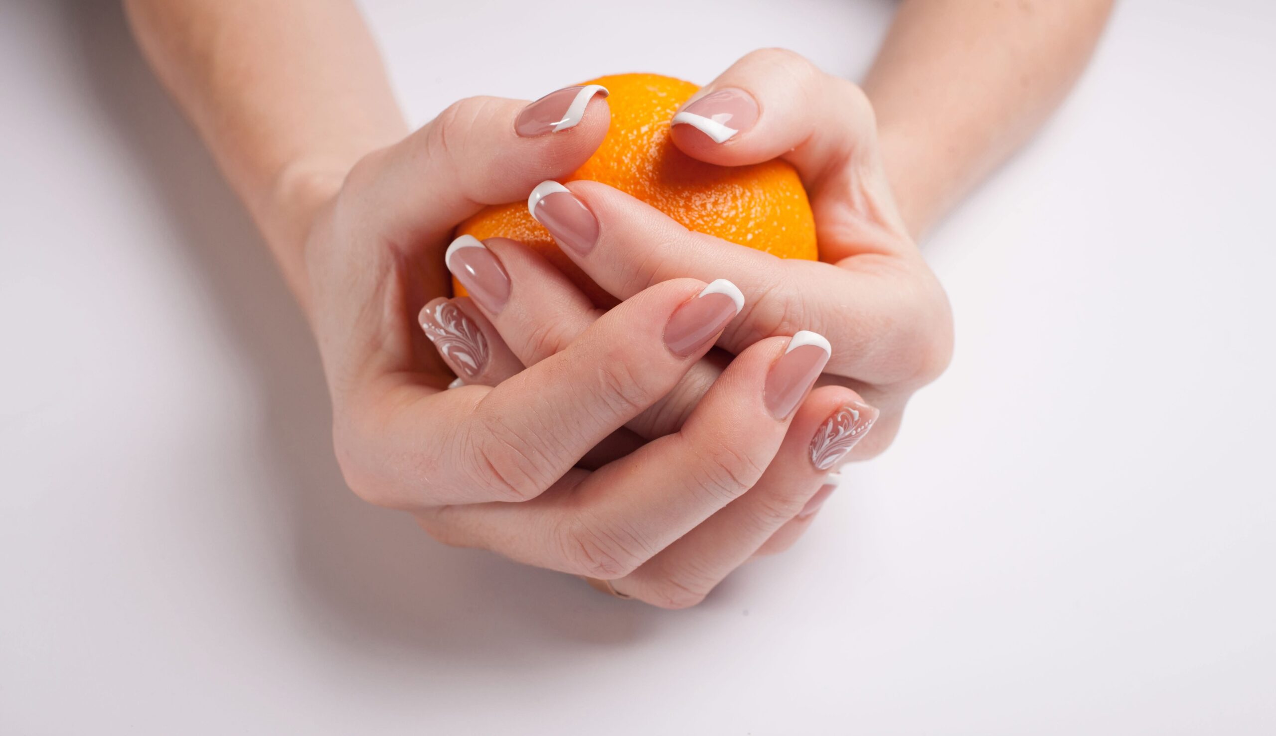 Home 1 beautiful manicure female hands hold orange scaled